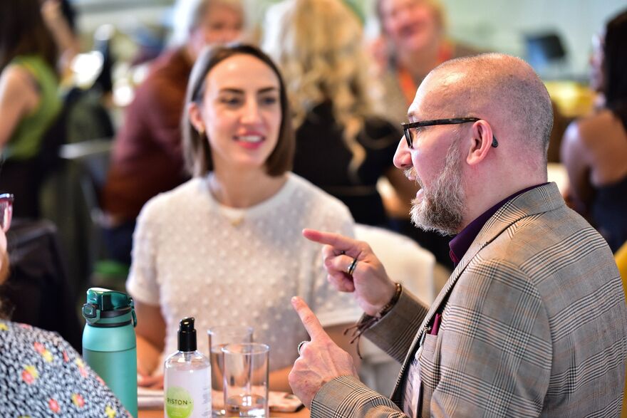 Photo from a PIF networking event. PIF quality manager Dan Wills is at the right of the image talking to a table of members.